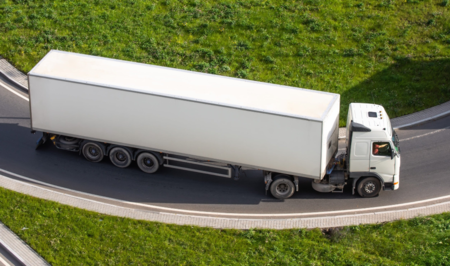 truck with a white trailer at the turn of the highway